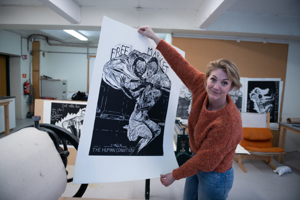 Kunstner Julie Ebbing holder oppe et av sine grafiske verk
